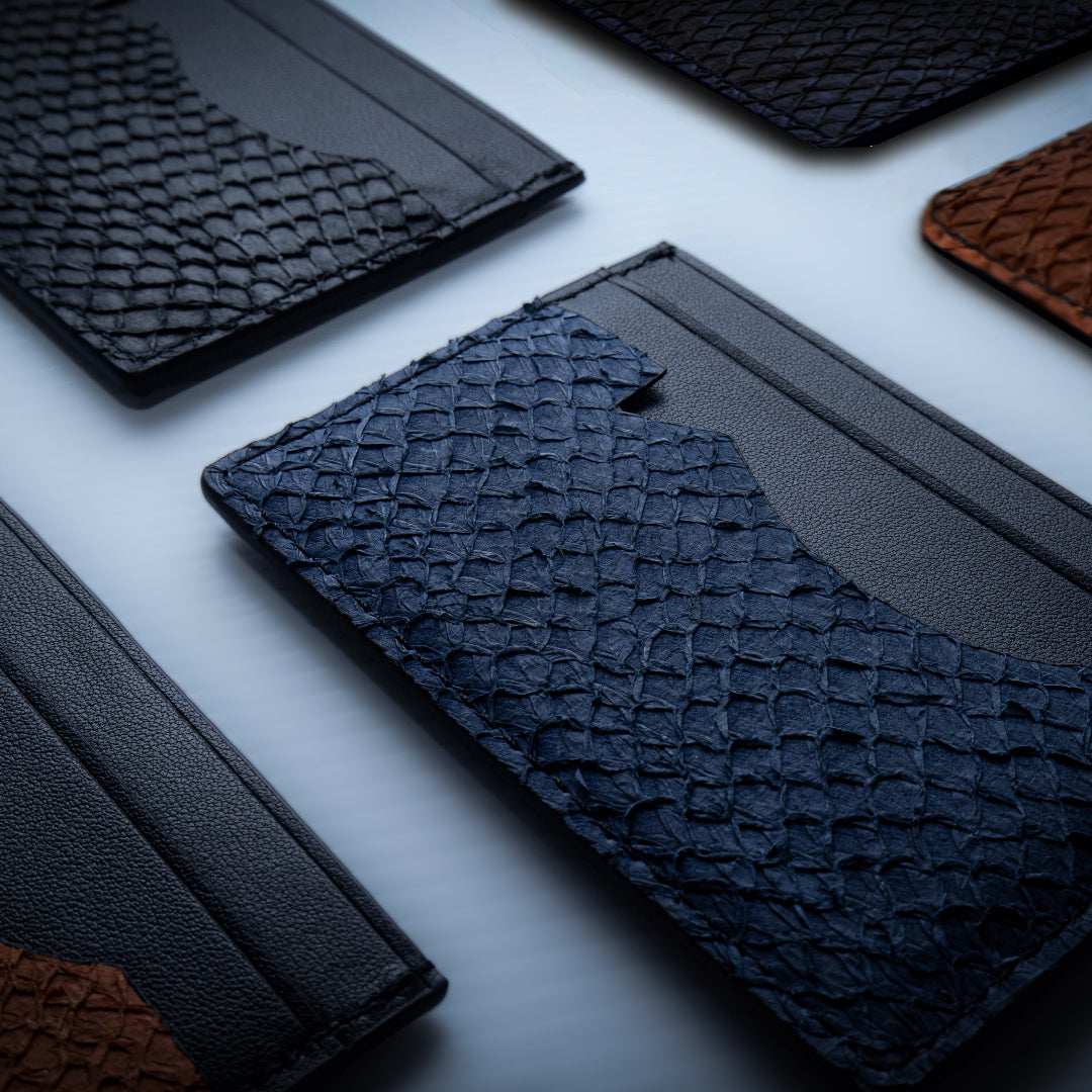 Collection of textured fish leather card wallets on a light background