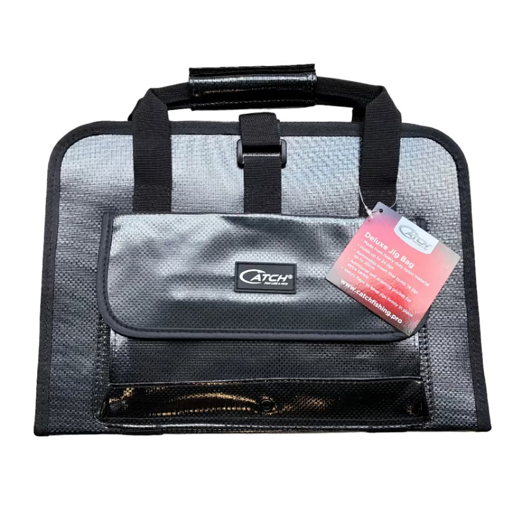 Black and gray fishing tackle bag with a red tag on a concrete surface