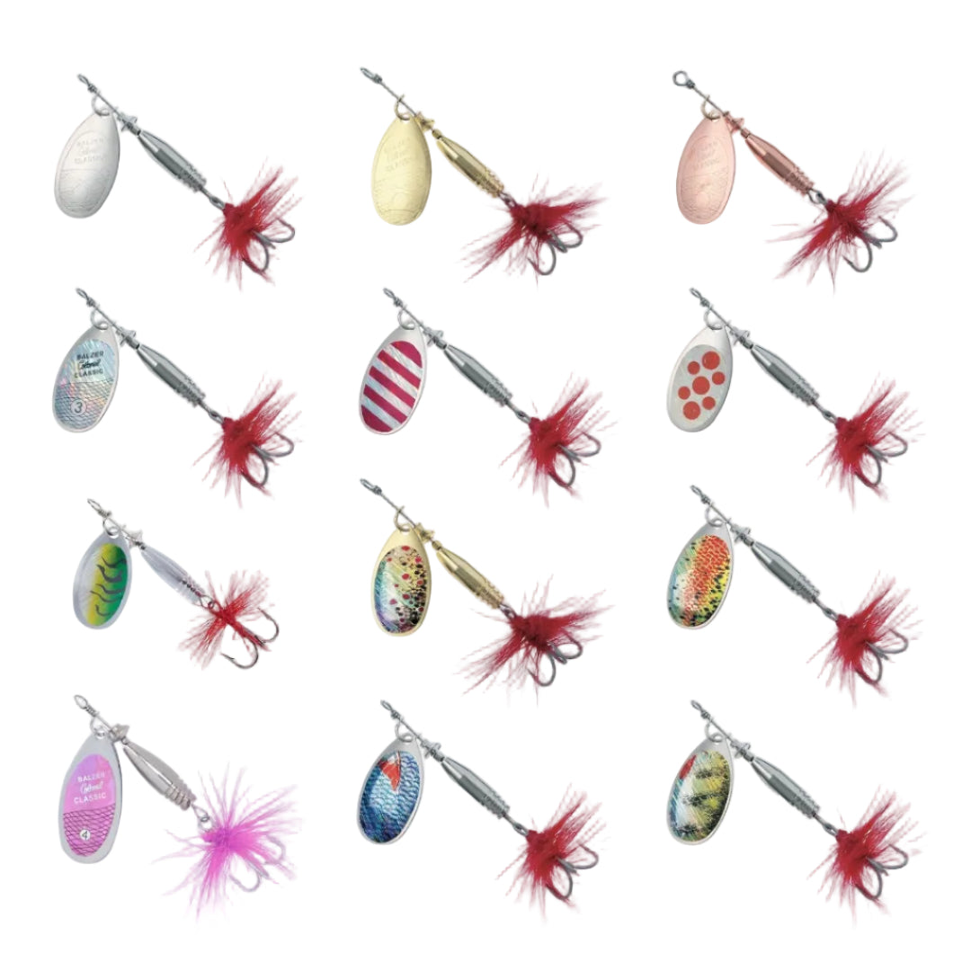 Twelve fishing spinnerbait lures arranged in a 3x4 grid on a plain white background. The lures have oval metal bodies in various colors and patterns, with red or pink feathered skirts and treble hooks.