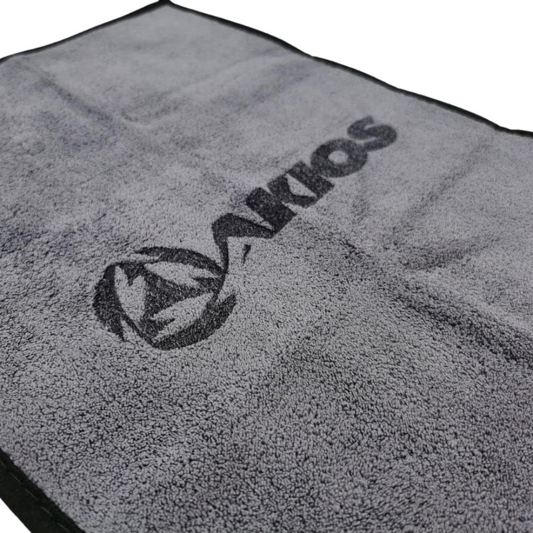 A gray microfiber towel with a black border and a large black Akios logo printed diagonally across the center.