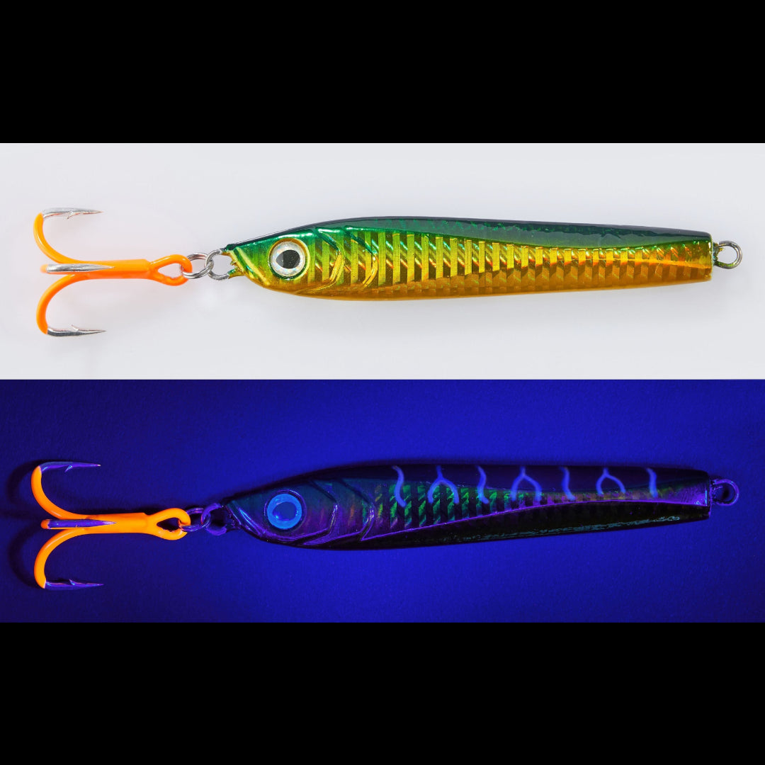 A fishing lure shown in two color states: a standard white background view with a metallic green-to-gold body and orange treble hooks, and a blue-violet UV-light view showing a black body with iridescent purple and blue flame-like patterns. The lure has a realistic eye and a split ring at the tail.